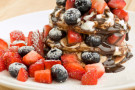 Torre di pancake con yogurt, cioccolato, fragole e mirtilli