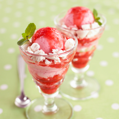 Coppa di gelato con salsa di fragole e meringhe