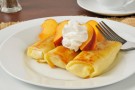 Crepes ripiene di crema con pesche e panna Crepes ripiene di crema con pesche e panna