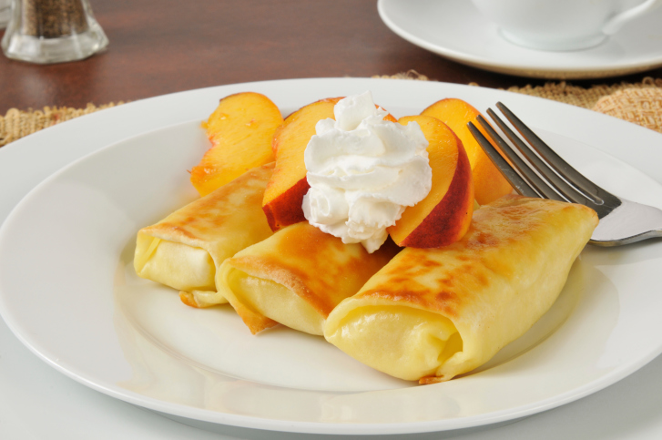 Crepes ripiene di crema con pesche e panna